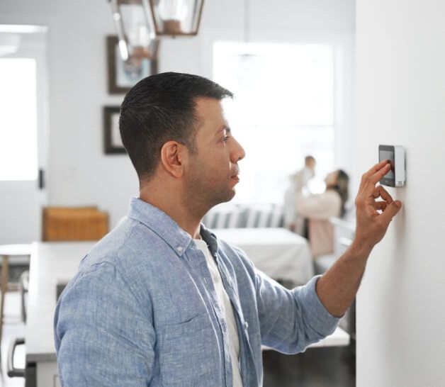 man adjusting thermostat